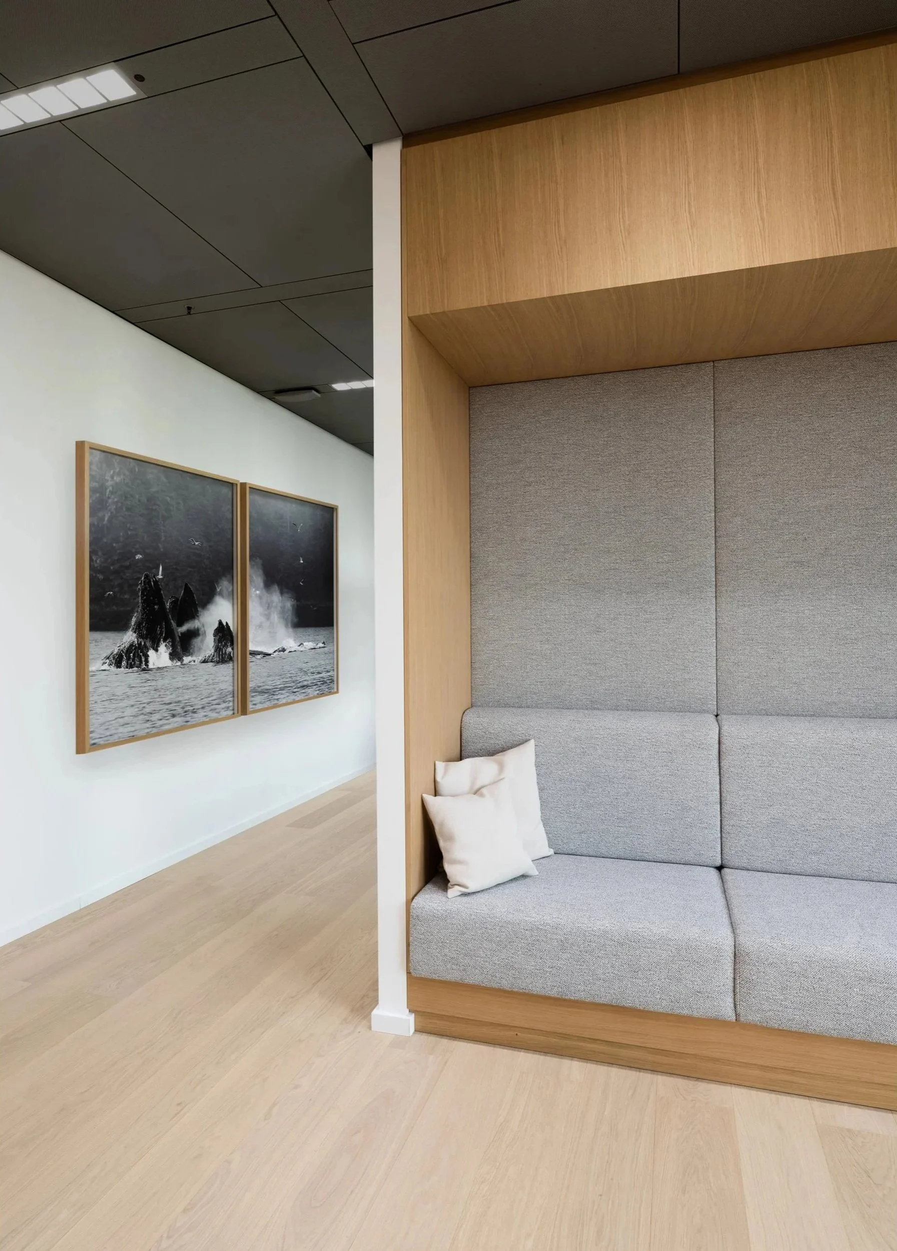 Moderne Sitznische mit grauer Polsterbank und Holzwand – Innenarchitektur