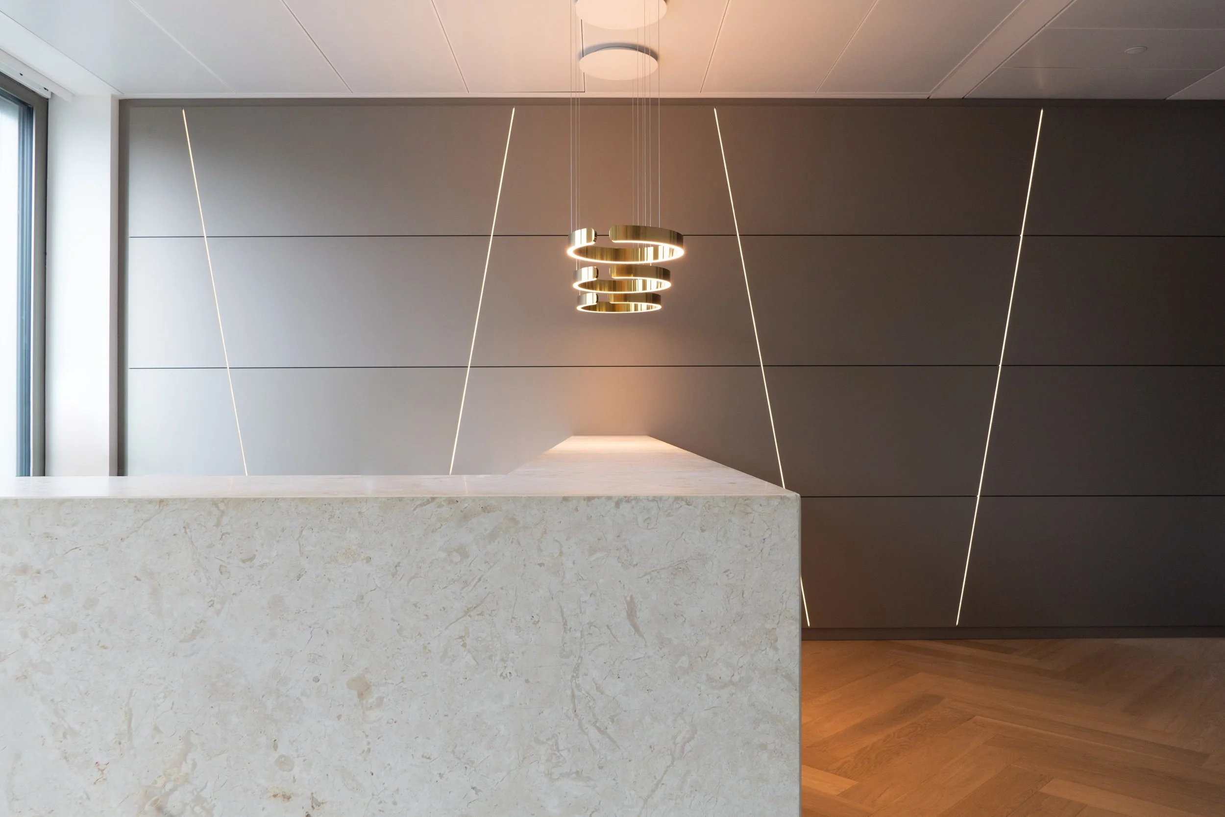 Moderner Empfangsbereich mit Marmortresen, LED-Wandpaneelen und Design-Leuchte – Innenarchitektur