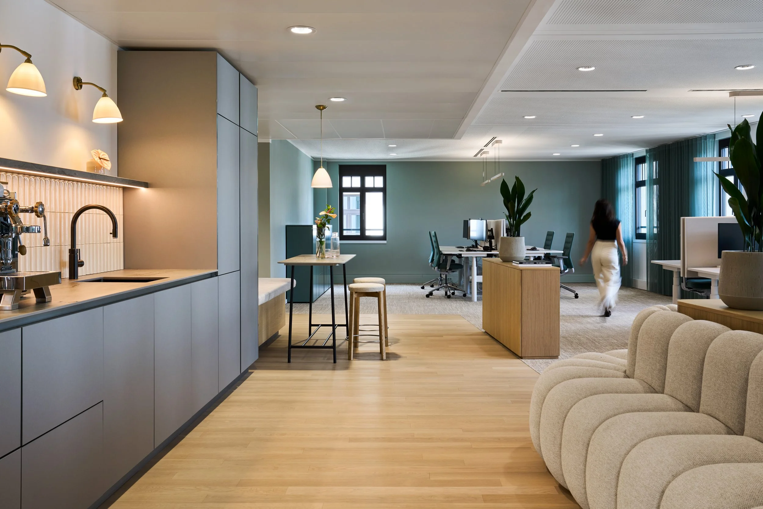 Moderner Coworking-Space mit Küchenzeile, Sitzbereich und Arbeitsplätzen – Innenarchitektur für Büroräume