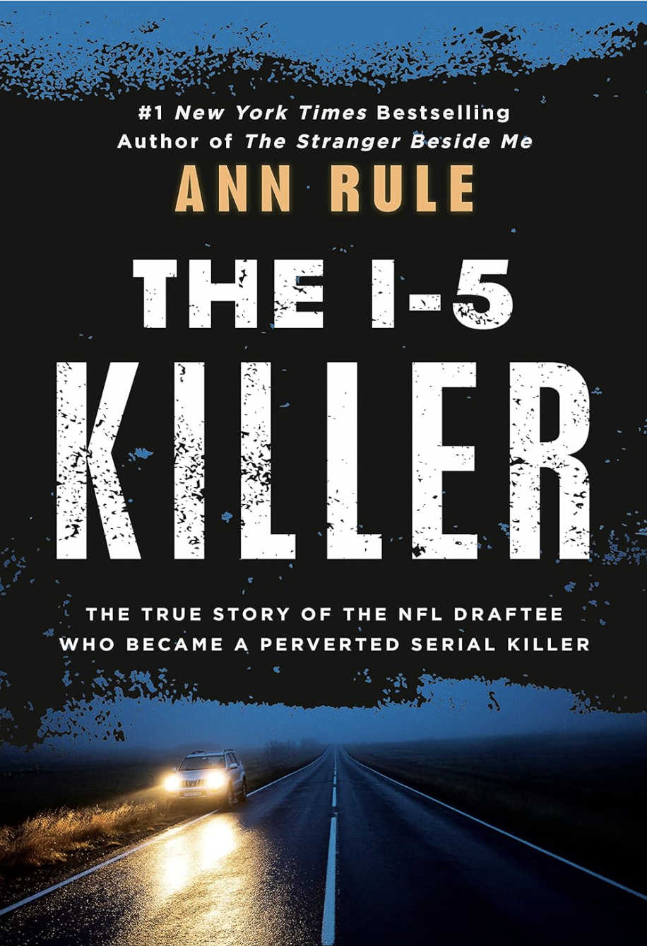 Book cover of 'The I-5 Killer' by Ann Rule, showing a dark road with a car with headlights on driving towards the camera, and trees on either side against a dark blue sky.