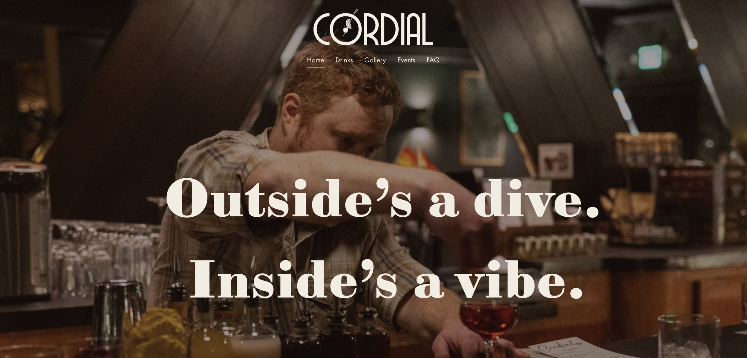 Interior of a bar with a bartender preparing drinks, the photo features warm lighting and wooden decor, with the phrase "Outside's a dive. Inside's a vibe." overlaid.