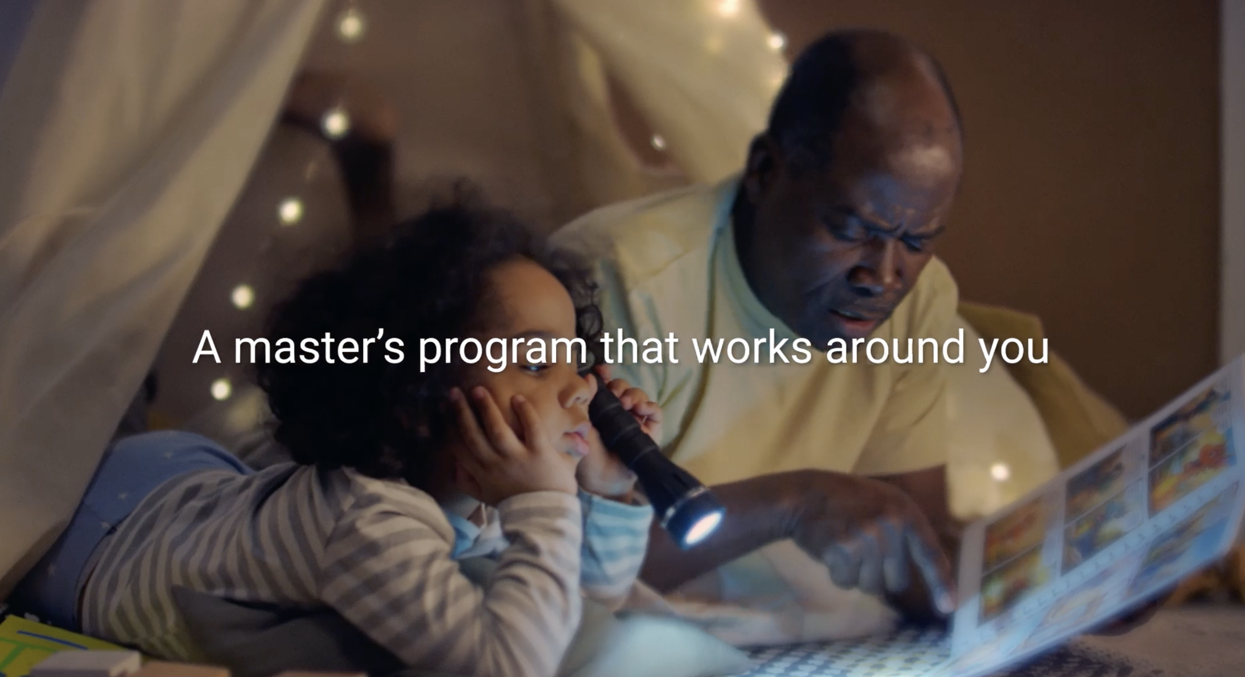 A father man and daughter lying in bed, reading a book together with a flashlight, in a cozy room with fairy lights, under a canopy. Text overlay says, 'A master's program that works around you.'