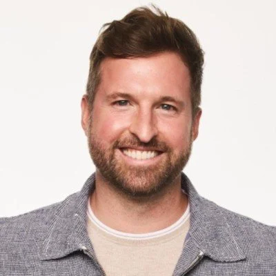 David Keplogle, wearing a gray jacket over a white shirt, against a plain white background.