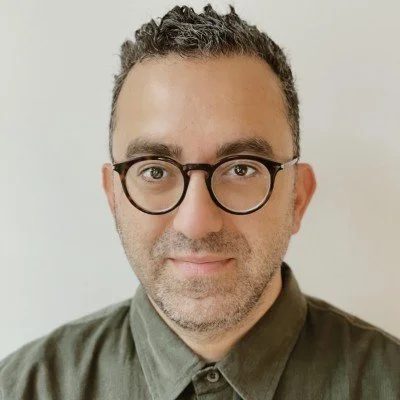 Kevin Nabipour, wearing a green shirt, looking directly at the camera against a plain light background.