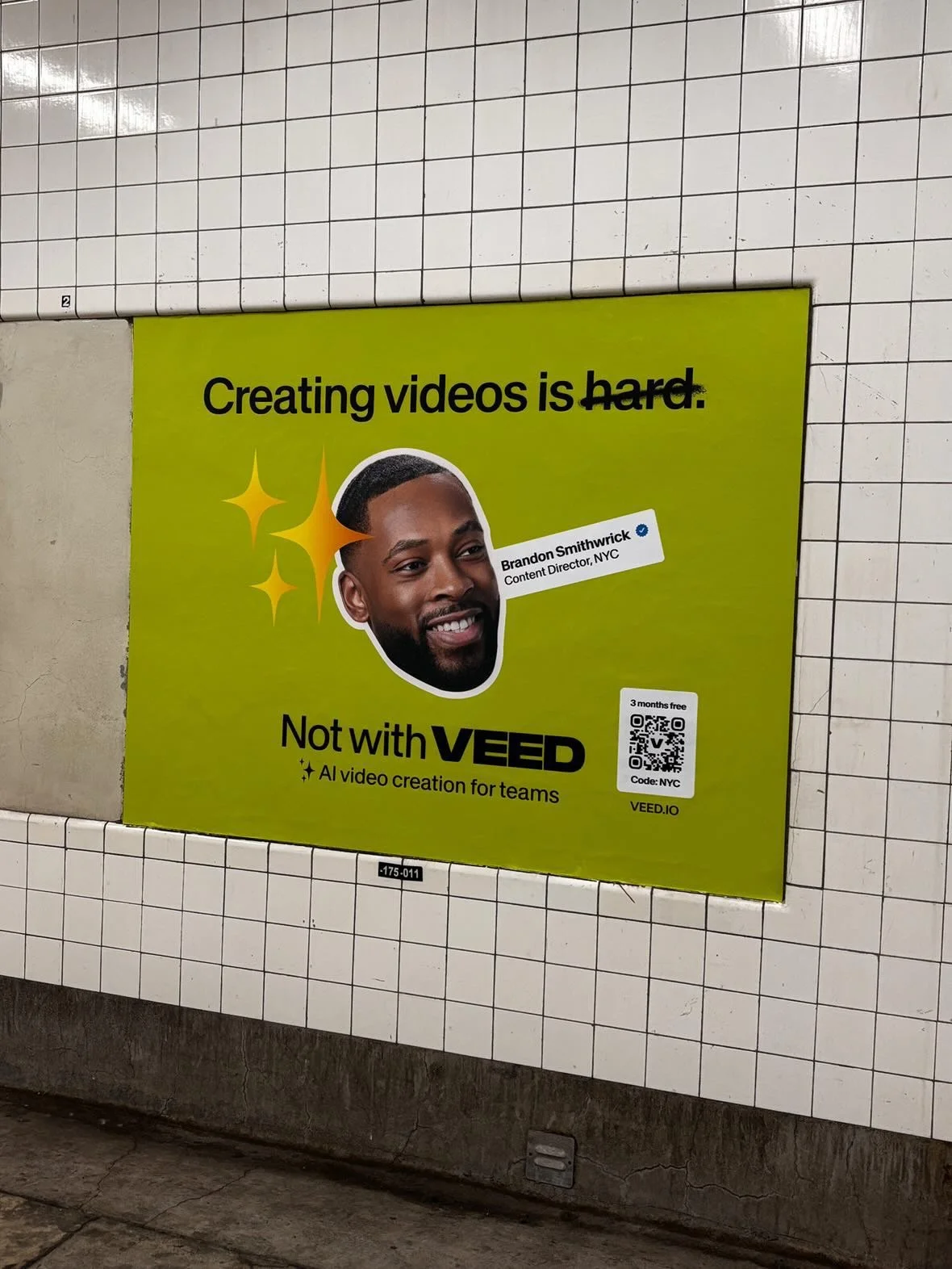 A bright green advertisement for VEED on a tiled NYC subway with Brandon Smithwrick on it.