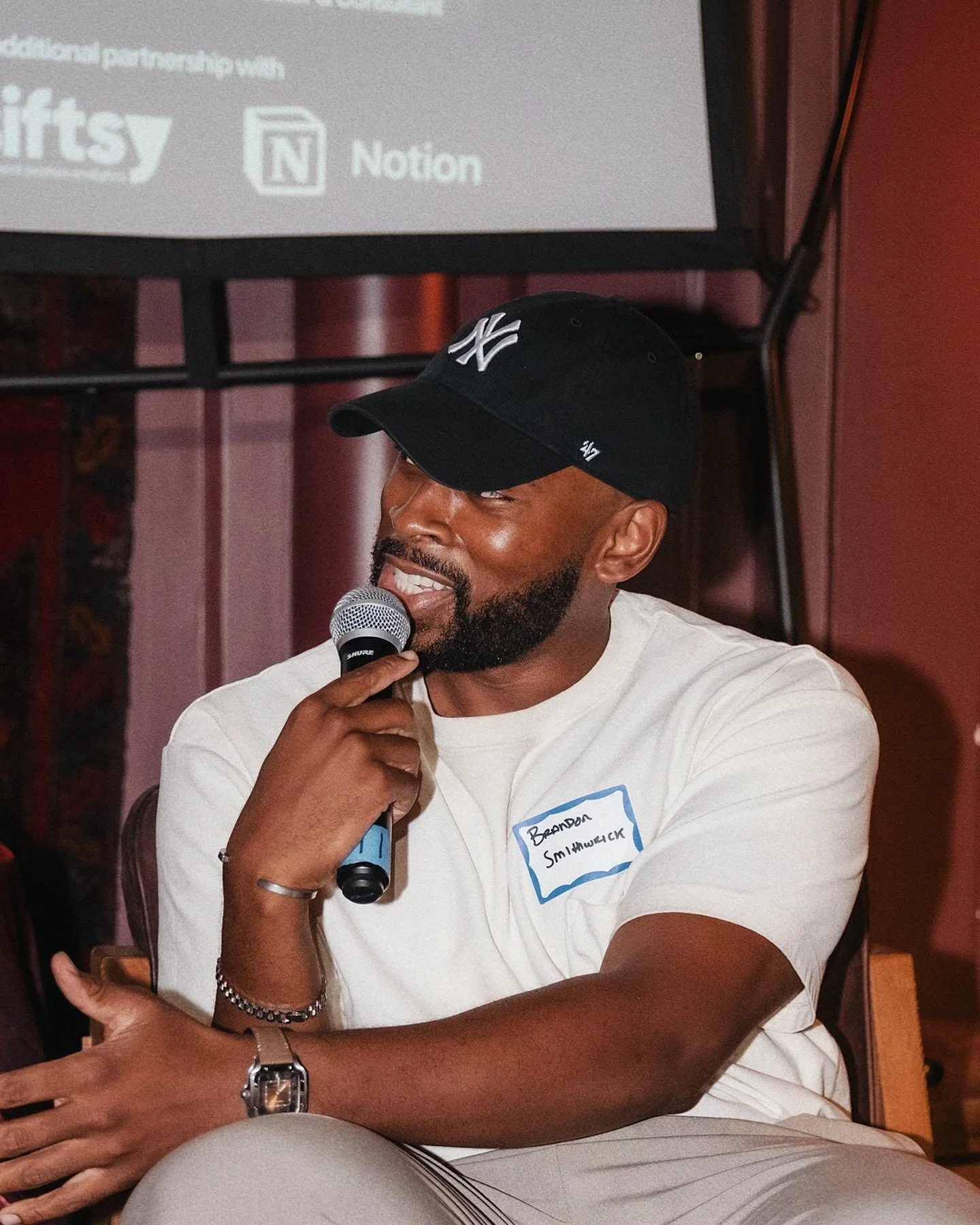 Brandon Smithwrick speaking into a microphone at an indoor event.