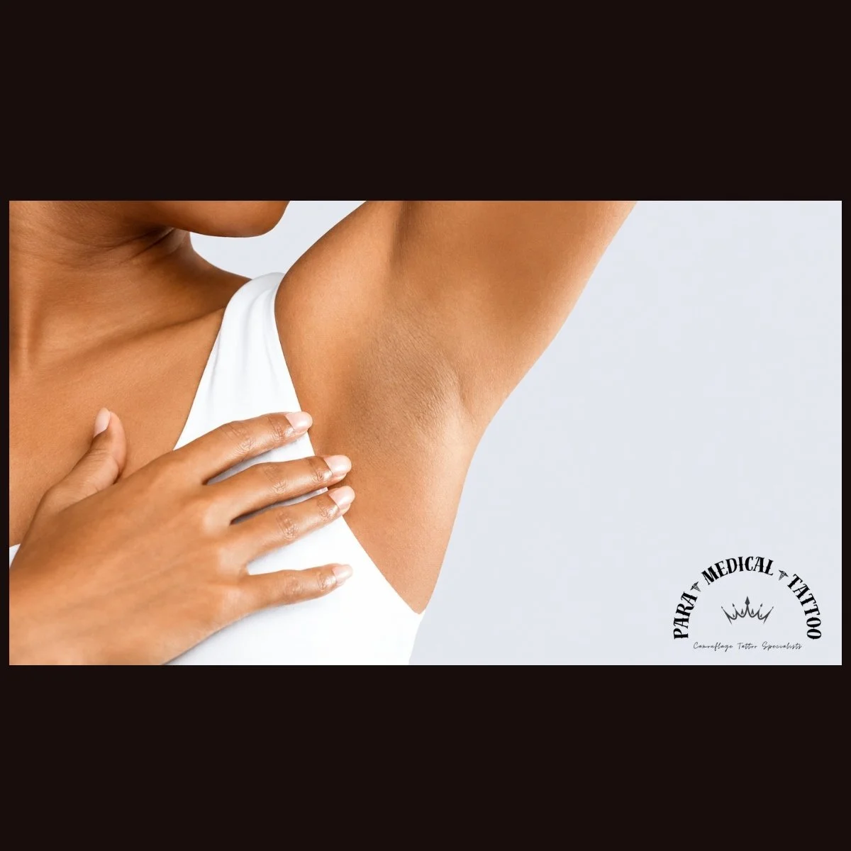 Close-up of a woman with her hand on her chest, showing her armpit hair, wearing a white top, with a plain background and a logo for Patra Medical Tattoo in the bottom right corner.