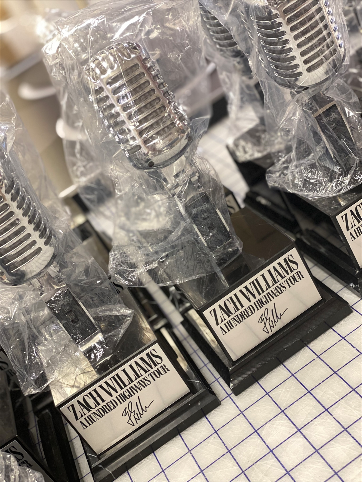 Promotional display of vintage microphones with Zach Williams' 'A Hundred Highways Tour' signed plaques.
