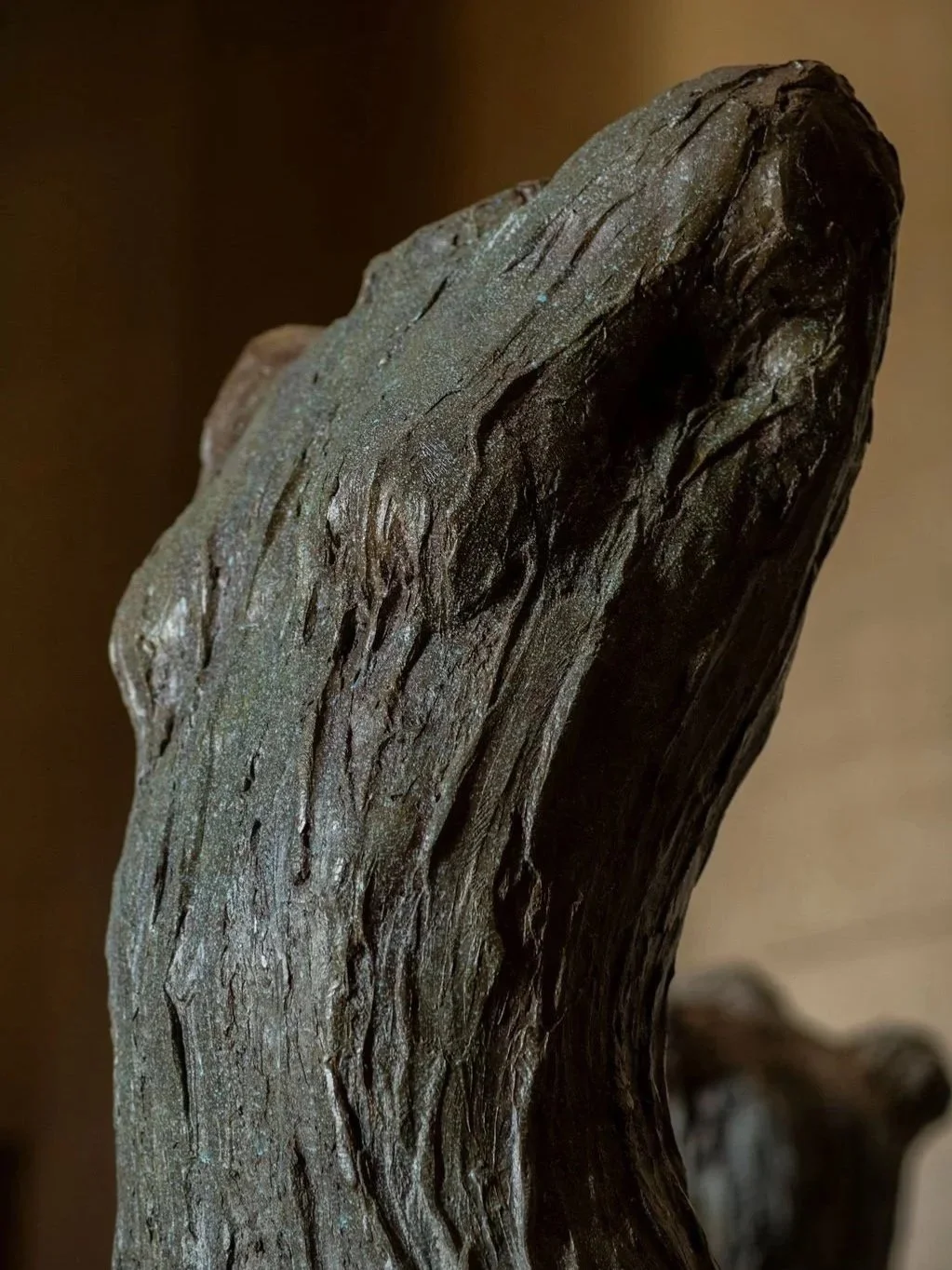 Close-up of a weathered, textured sculpture and torso with textured, cracked surface. At parthenon Museum.