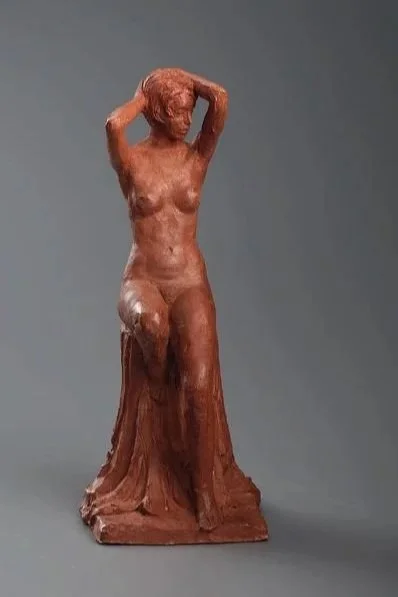 Bronze sculpture of a standing female figure with arms raised behind her head.