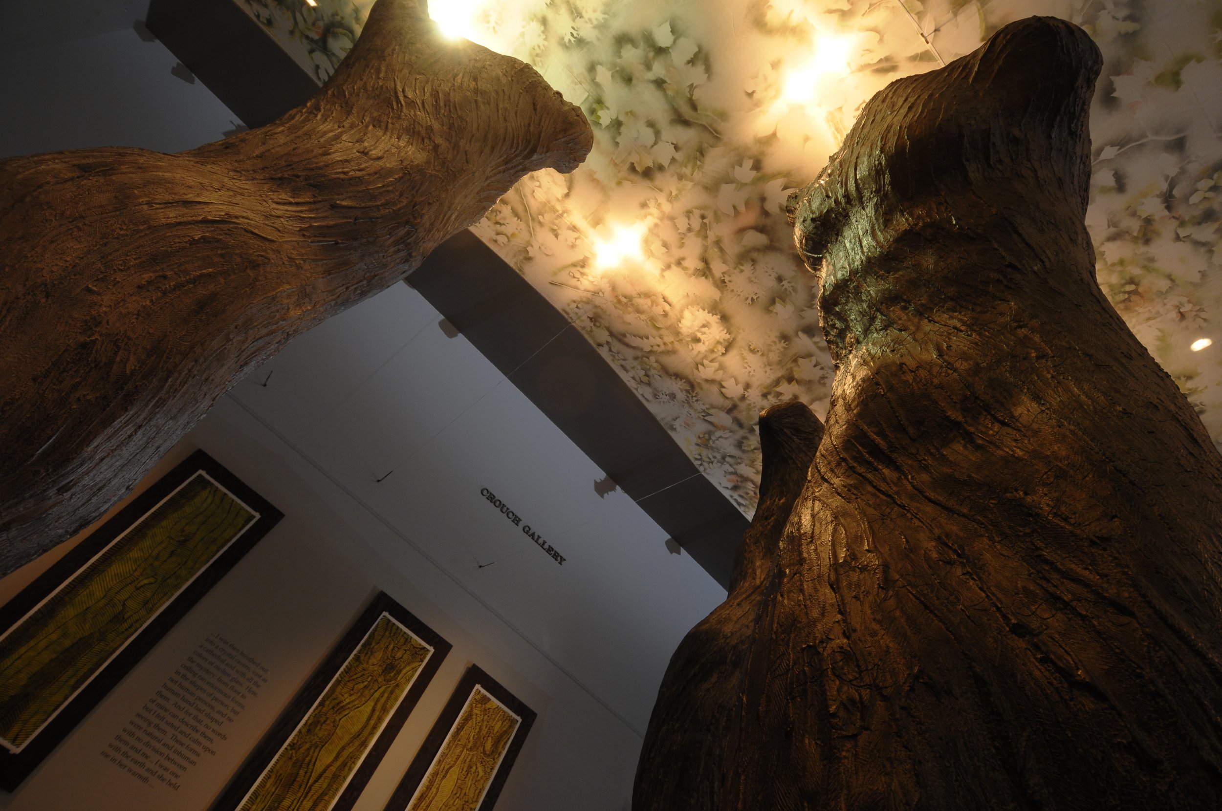 A large decorative tree sculpture in an art gallery with printed panels on the wall behind. Dream Forest Installation.