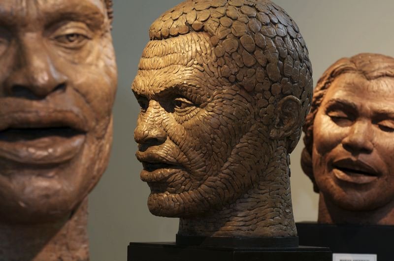 Three detailed sculptures of prominent figures, with the central bust resembling a man with a textured face, likely made of clay or similar material.  Cultural Heroes