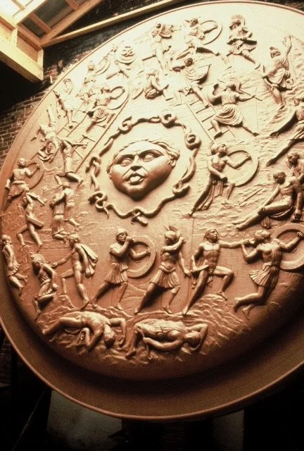 A large circular relief sculpture depicting various figures on Athenas Shield. Athena Parthenos in Parthenon Museum Nashville. 