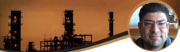 Una fotografía de estructuras de una planta industrial con un fondo en tonos sepia, y un recuadro circular en la esquina superior derecha en el que aparece un hombre sonriente con gafas y pelo oscuro.