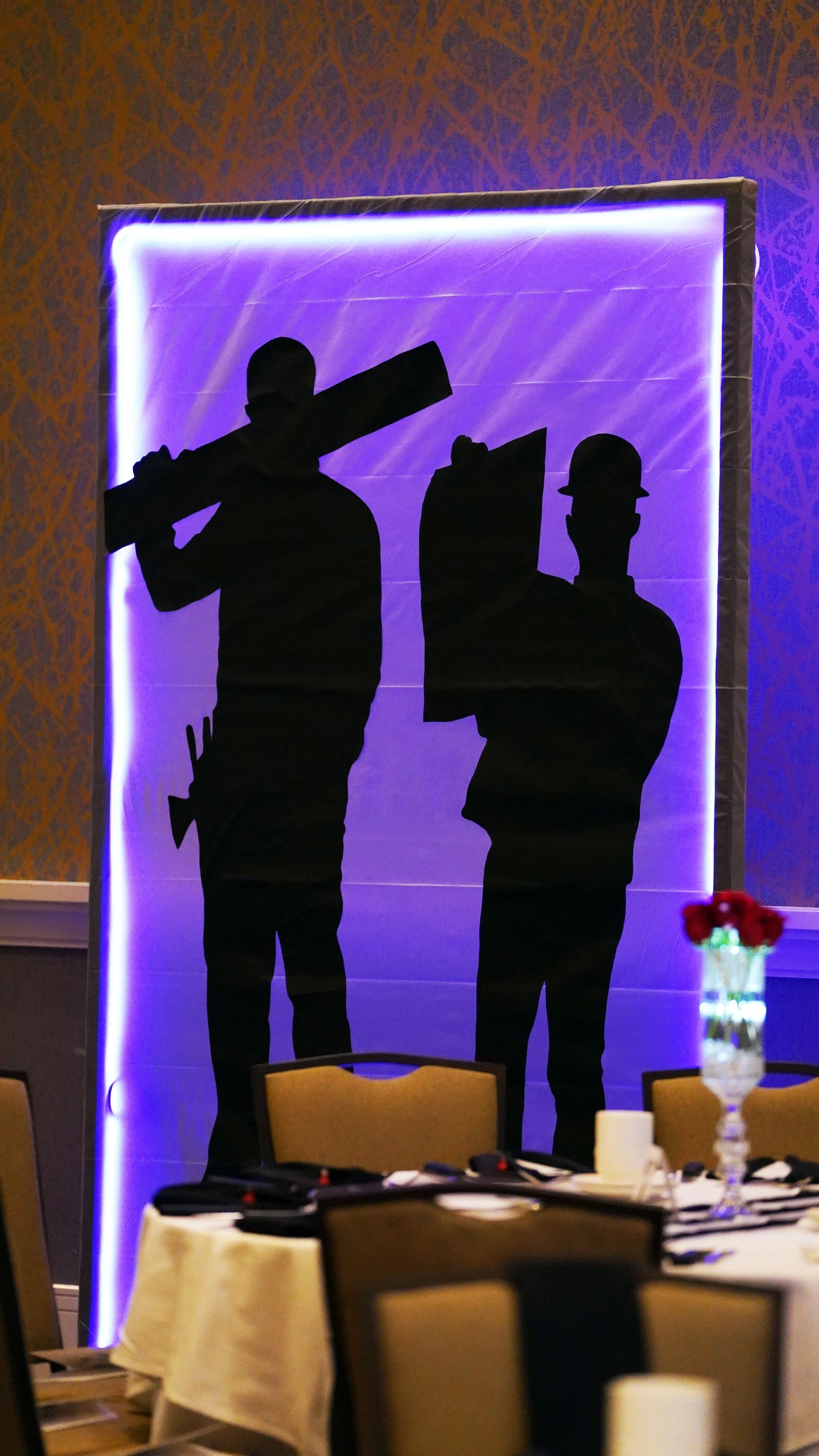 Custom-designed James Bond-inspired silhouette installation featuring building tools instead of weapons, creatively tailored to reflect the nonprofit organization and its industry.