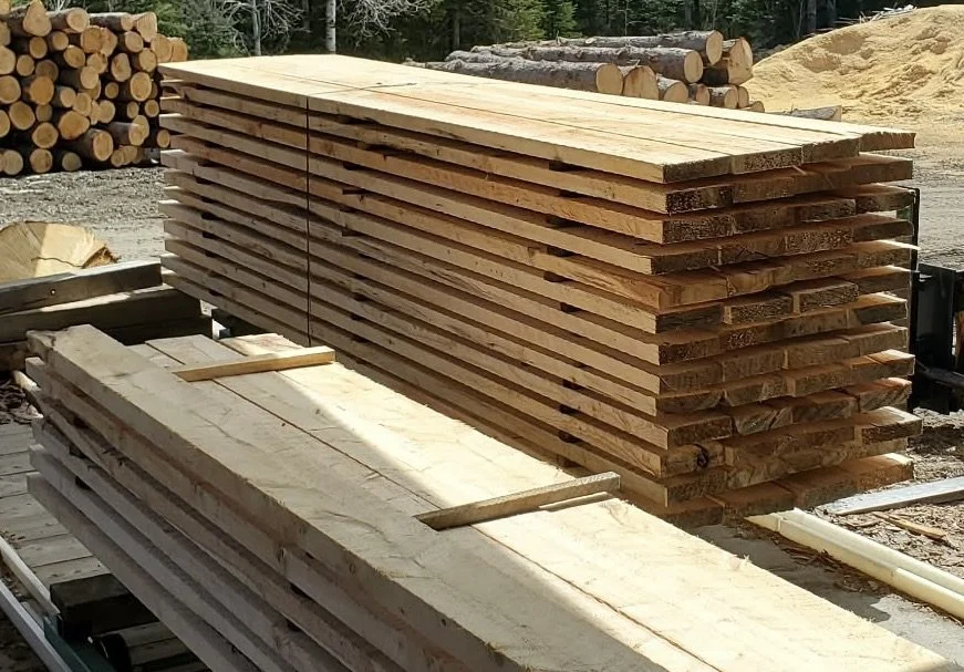 rough lumber piled neatly and ready to be loaded onto your trailer