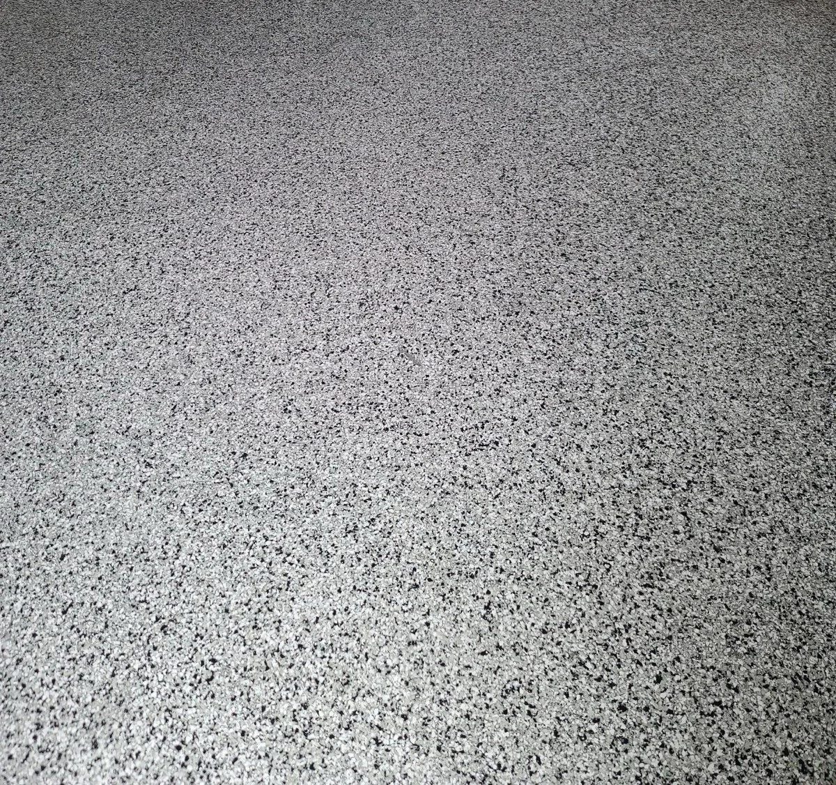 Close-up of a speckled gray and black textured surface, possibly a countertop or flooring.
