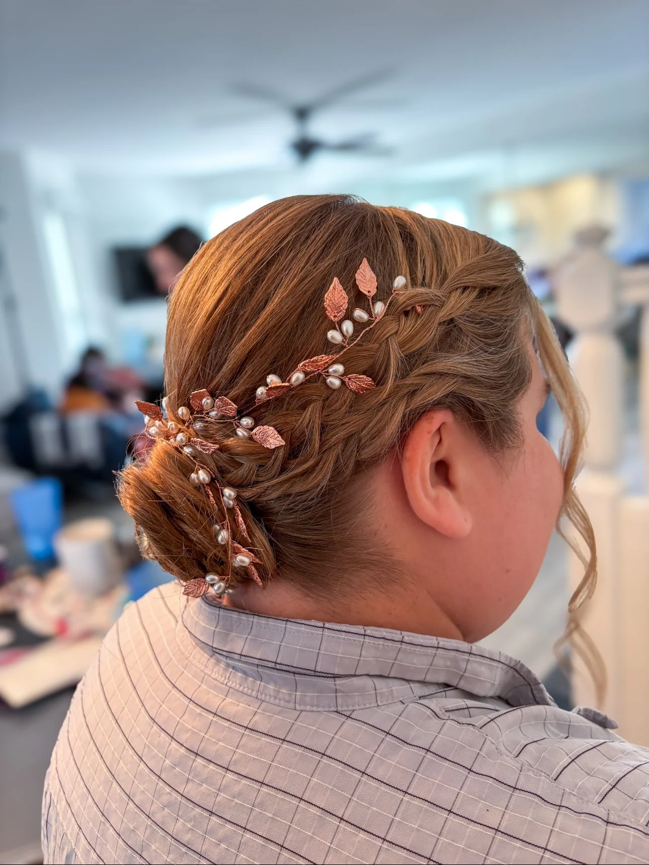 Woman with styled hair wearing a decorative hair accessory with pearls and leaves