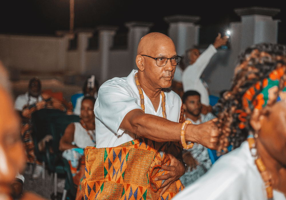 A man dressed with Kente and dancing at a Ghanaian naming ceremony for diasporans