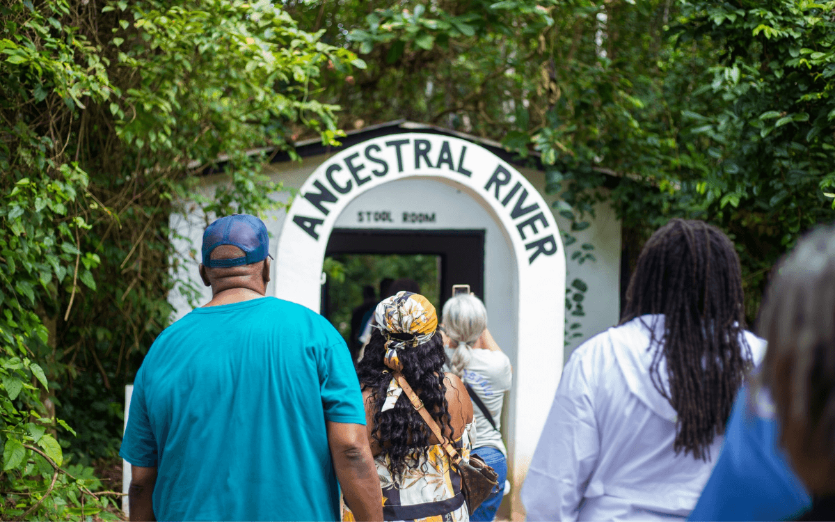 A photo of tour guests walking through a door at the Ancestral River at Assin Manso