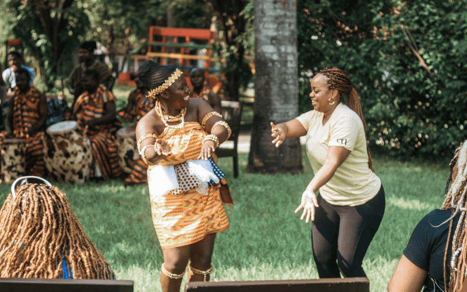 Two women dancing together in a drumming and dance tour experience