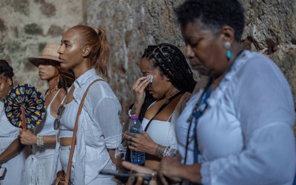 Group of diasporan women standing in a slave dungeon at the Cape Coast Castle.