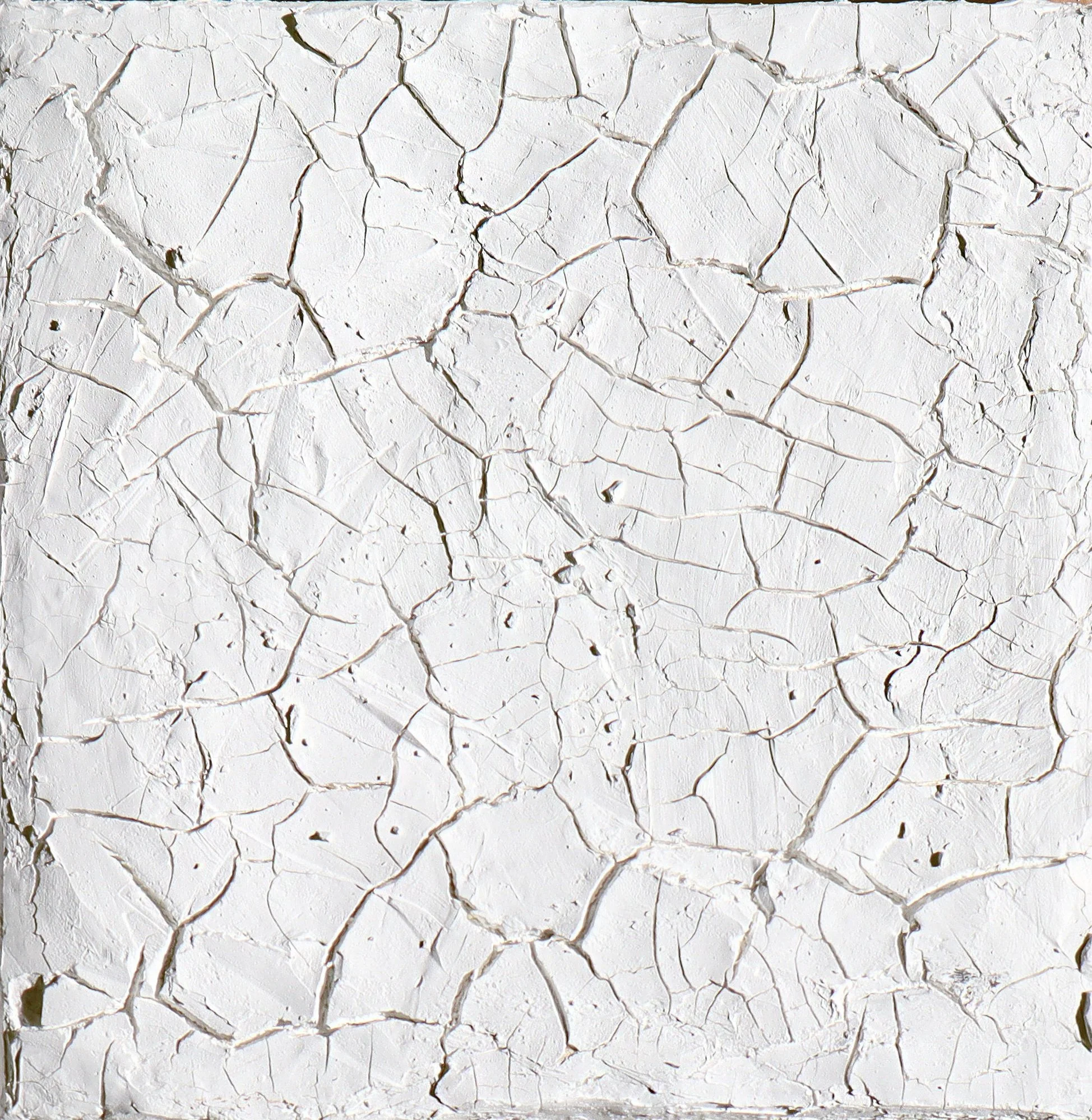 Close-up of a white wall with cracked, peeling paint revealing superficial layers underneath.