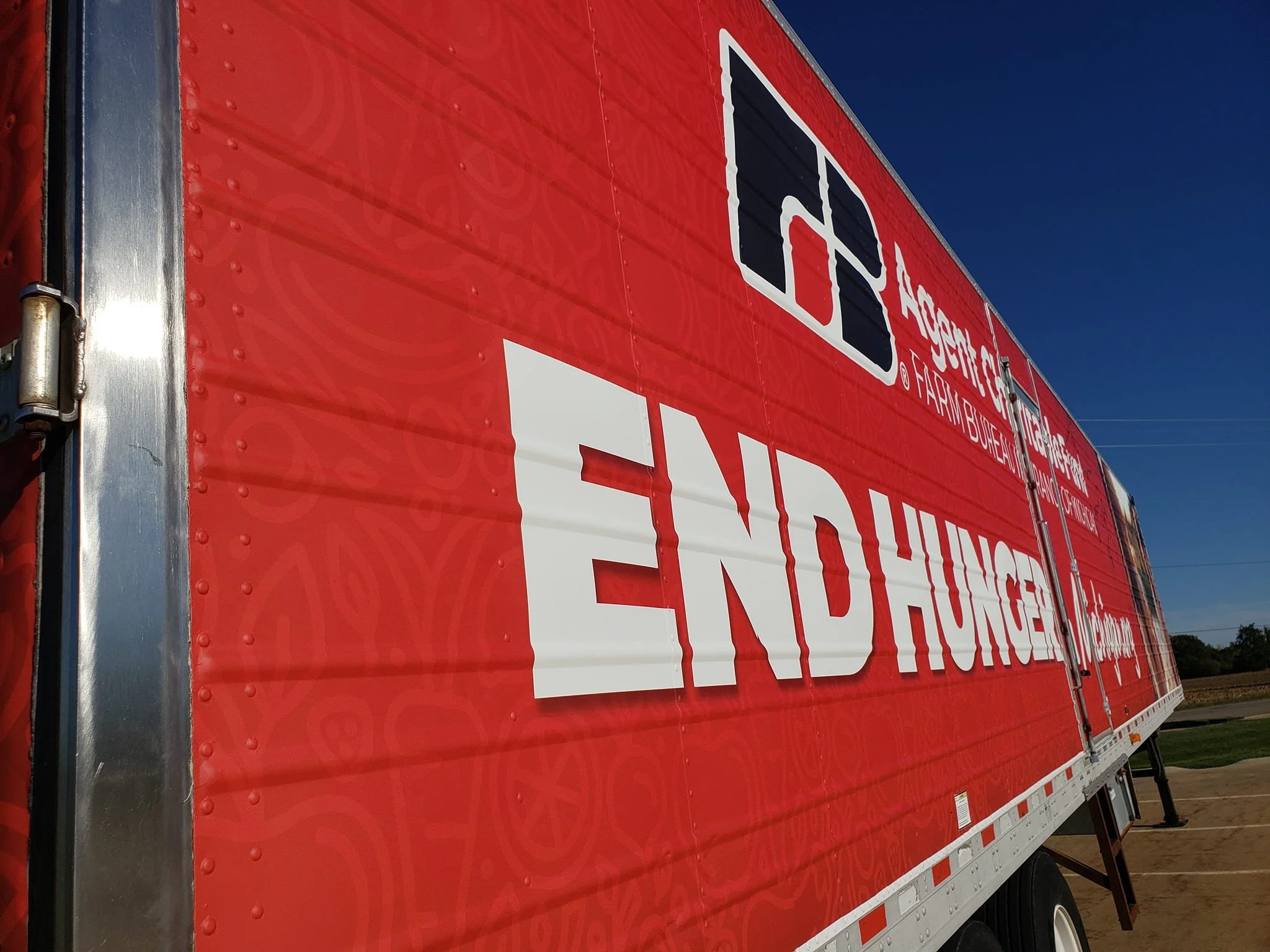 Red trailer with white and black text promoting a hunger relief organization, titled 'End Hunger'.