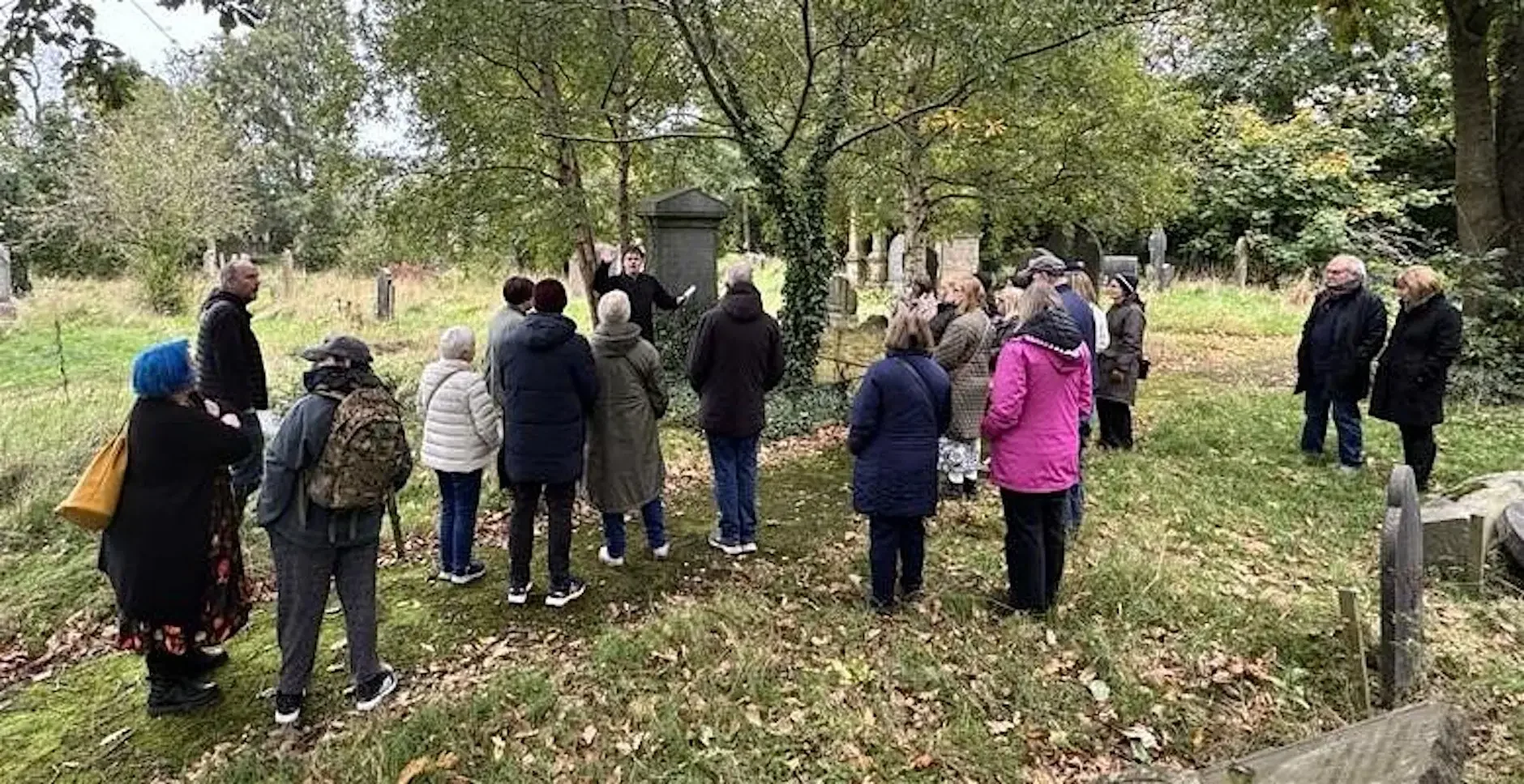 A photograph of a group of people enjoying a walking tour of Balmoral Cemetery with Peter McCabe and Stephen Beggs