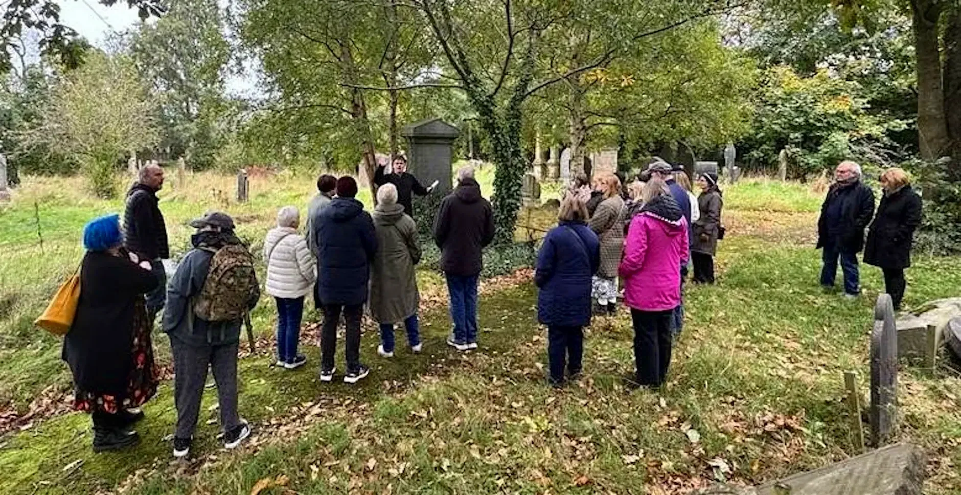 A photograph of a group of people enjoying a walking tour of Balmoral Cemetery with Peter McCabe and Stephen Beggs