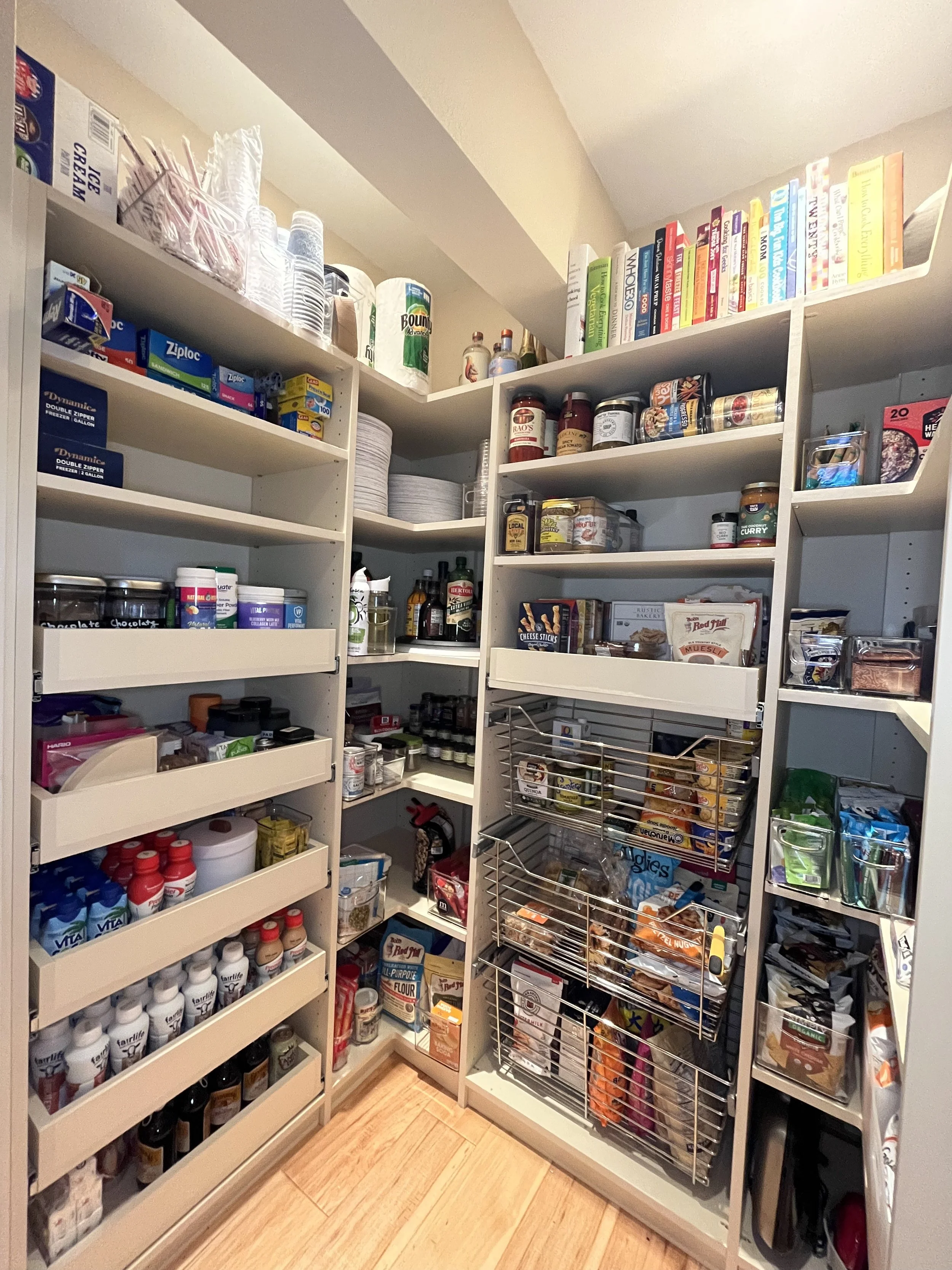 Pantry closet with shelves filled with food, spices, canned goods, and kitchen supplies.