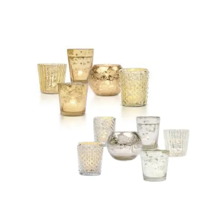 A collection of decorative candle holders in gold, silver, and clear finishes.