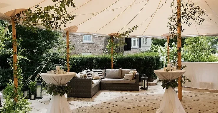 Outdoor sail cloth tent with couch, bar and cocktail tables