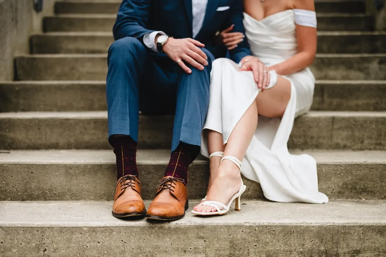 Bride and groom sitting together on the back steps at City Hall Kingston