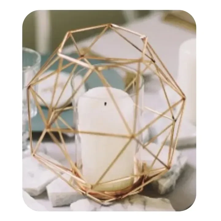 Decorative candle holder with a white candle inside, surrounded by white stones and a geometric wooden frame.