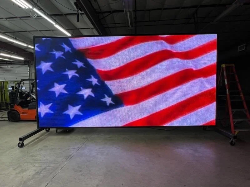 Large digital screen displaying an American flag with red and white stripes and a blue field with white stars.