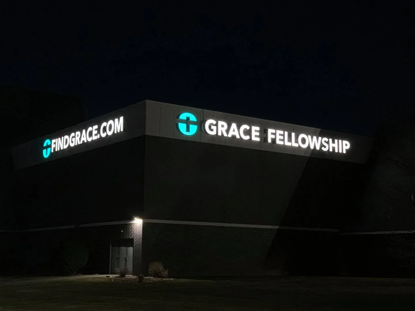 Nighttime photo of a building with illuminated sign reading 'FINDGRACE.COM' and 'GRACE FELLOWSHIP' with a cross logo.