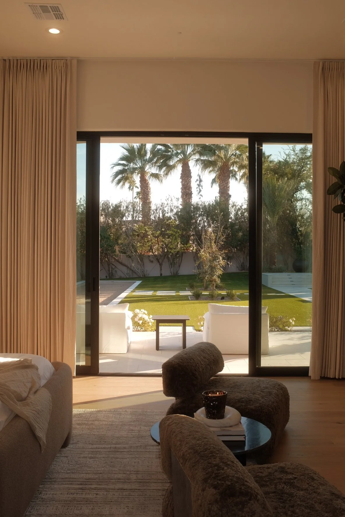 Luxury living room in a Scottsdale new development with sliding glass doors opening to a backyard patio and palm trees