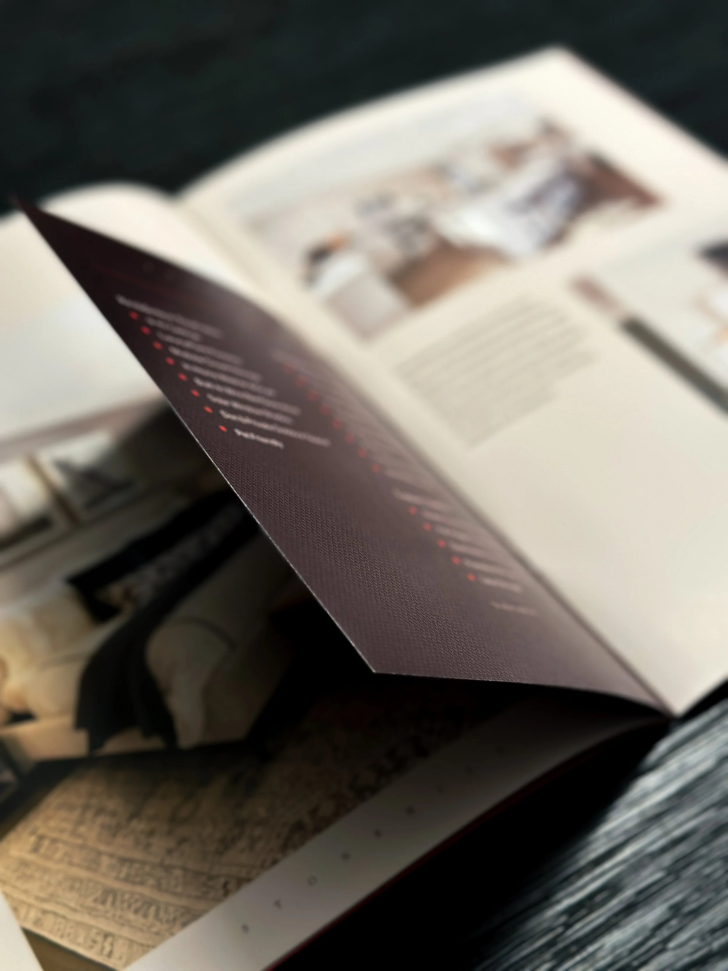 Brochure spread with mini-maroon pages inset in the larger brochure that detail out the amenities.