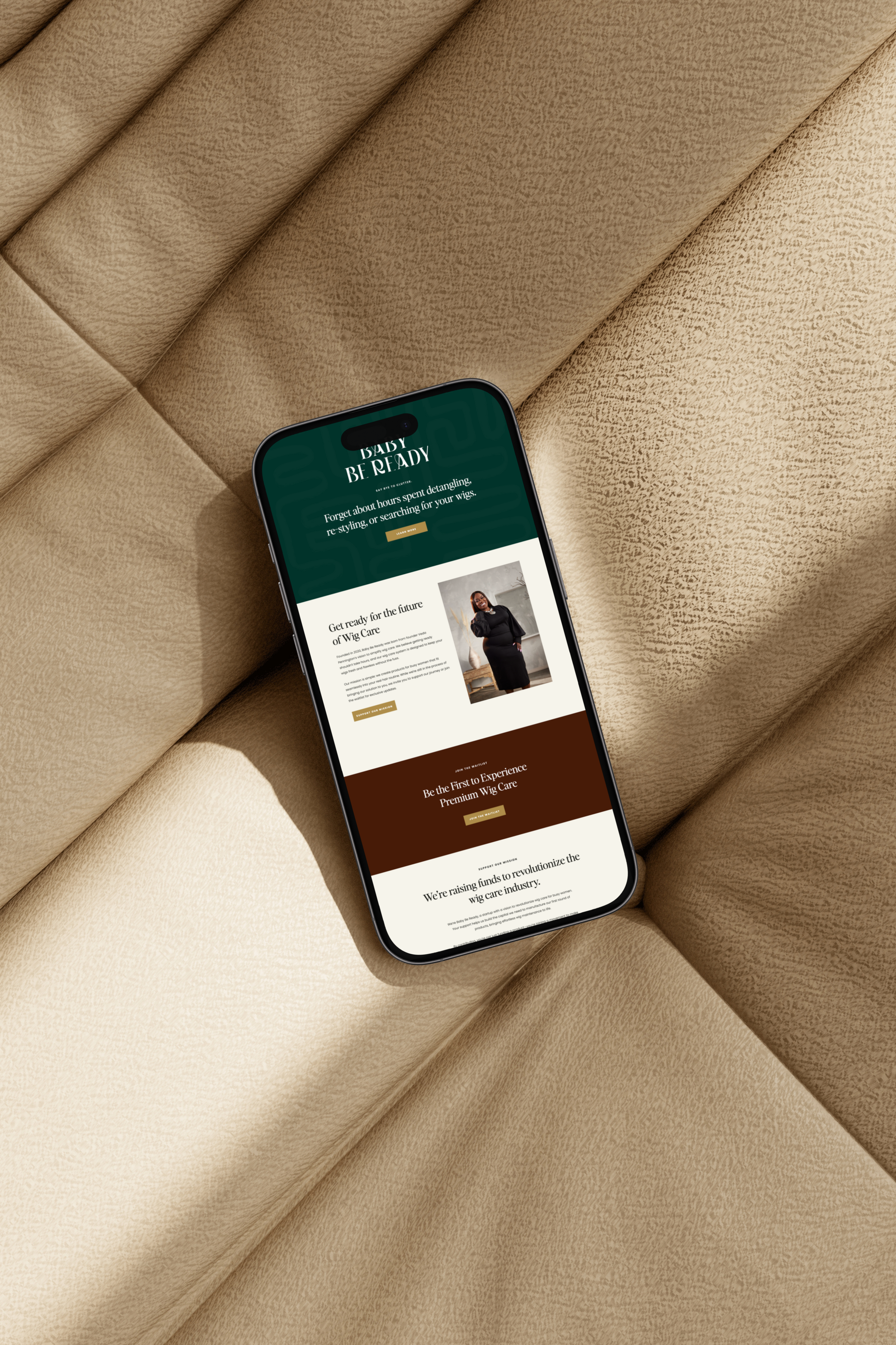 Close-up of a smartphone displaying a website called 'Baby Be Ready' on a beige textured fabric surface.
