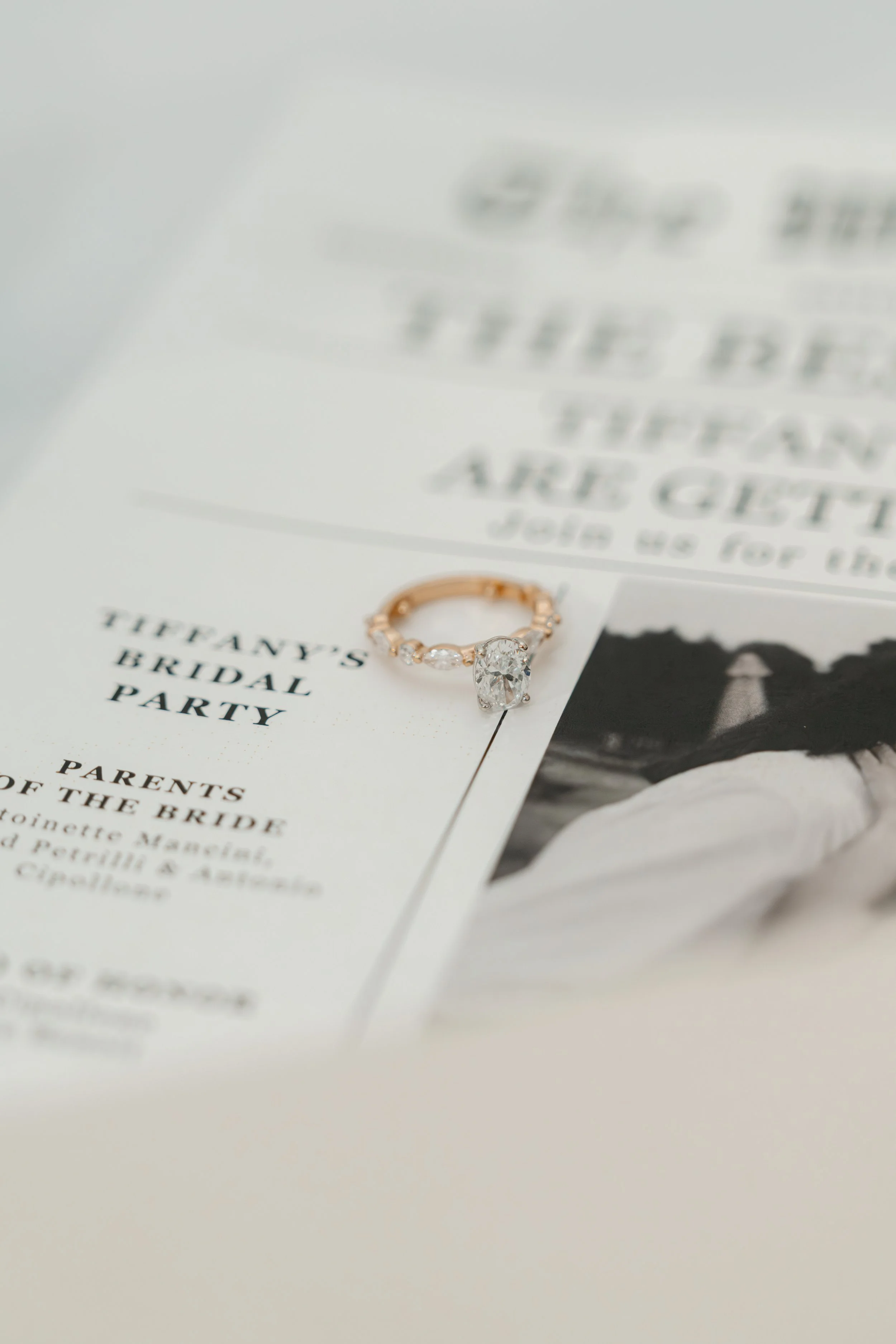 Close-up of a wedding ring with diamonds on a bridal shower invitation for Tiffany's Bridal Party, with a black and white photo of a bride on the page.