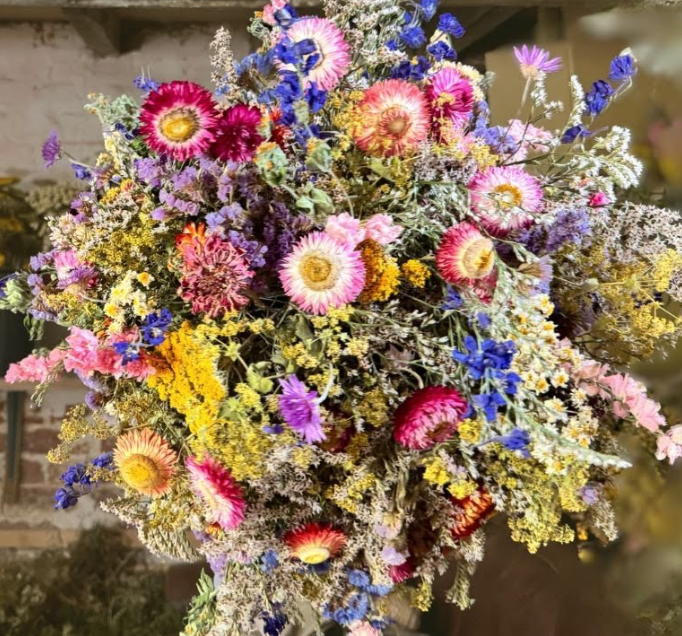 A large bouquet of dried flowers in pink, yellow, purple, and blue colors.