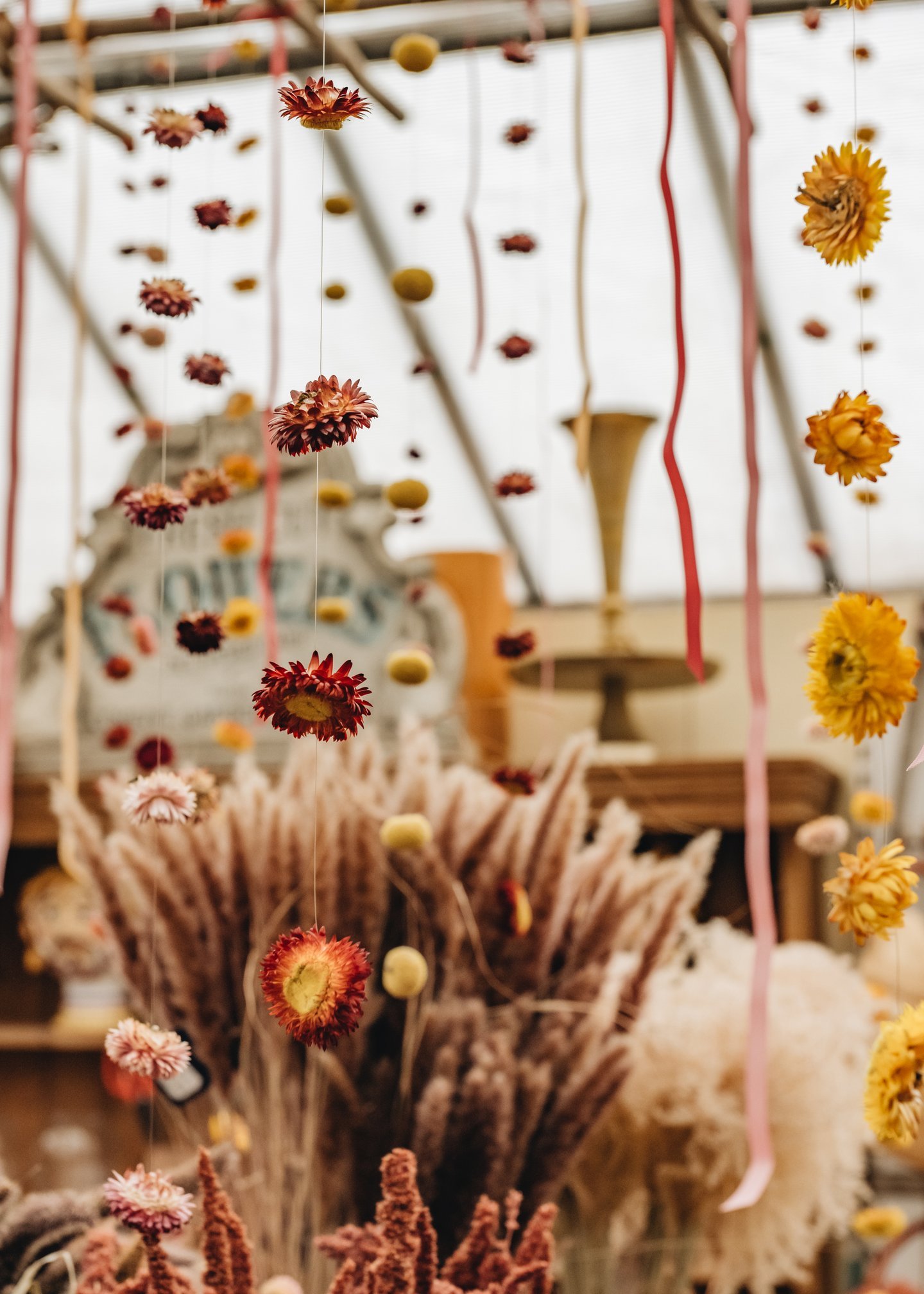 Hanging decorative flowers and ribbons in a flower shop or craft store.