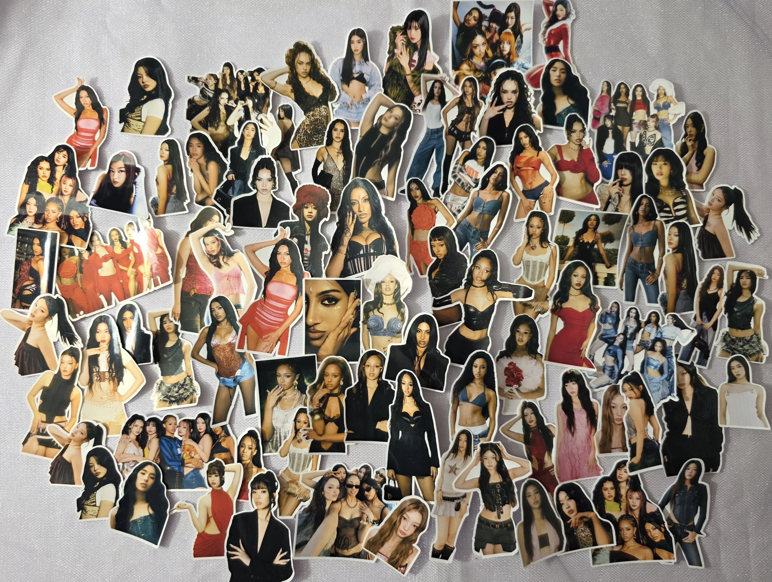 A collection of numerous stickers featuring women in various fashionable outfits and poses, arranged on a flat surface.