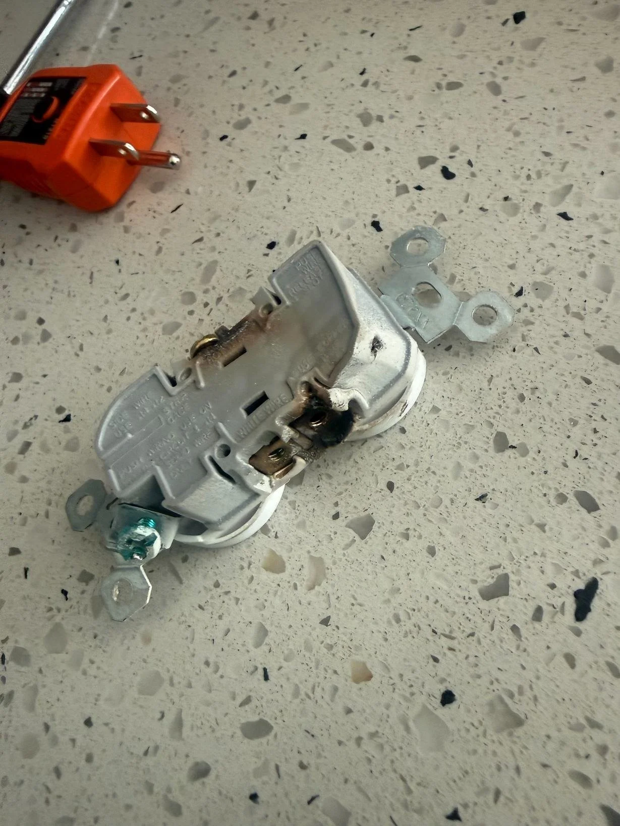 Electrical component and mounting hardware documented during a residential electrical repair and replacement project.