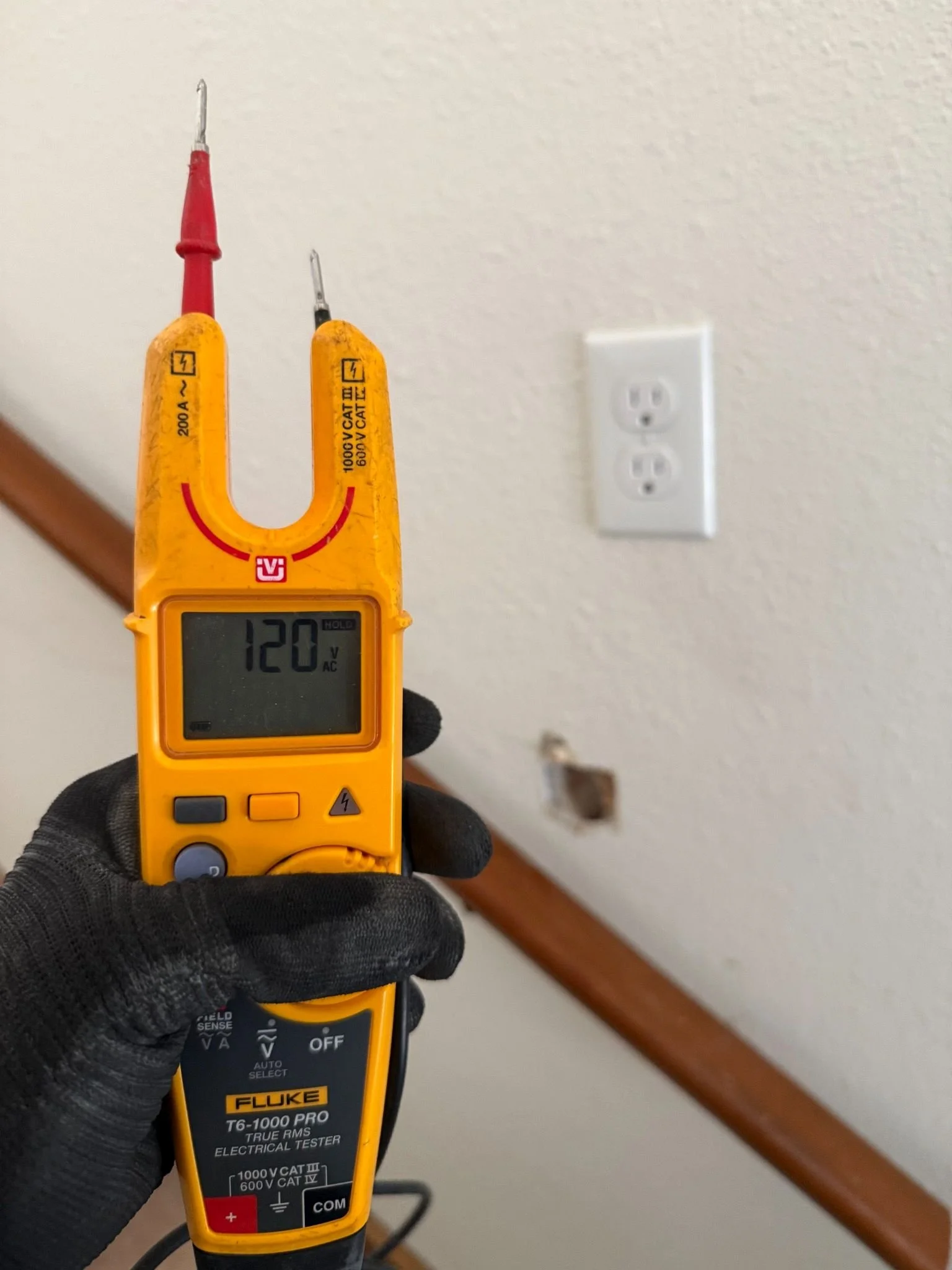 Professional voltage testing performed at a residential wall connection to diagnose power and verify proper electrical operation.
