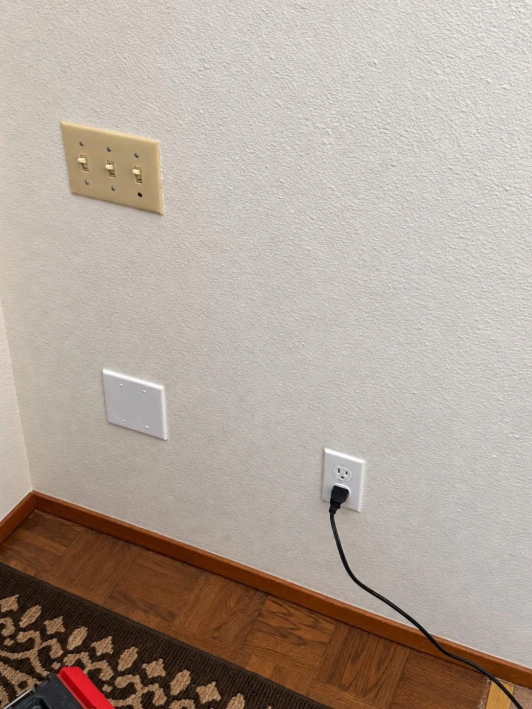 Finished residential wall outlet installation providing a convenient power connection with wiring neatly routed along the wall.