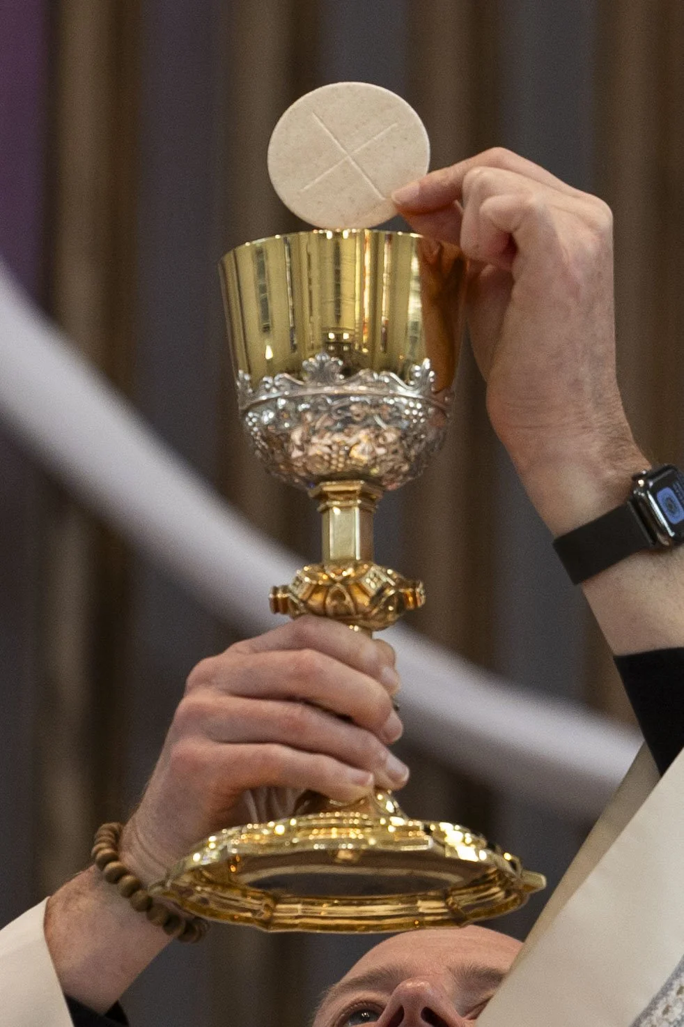 Pastor Joe Seipp holds a communion wafer over a chalice of wine April 11, 2026 at St. Andrew’s Catholic Church in Murphysboro, Illinois. 