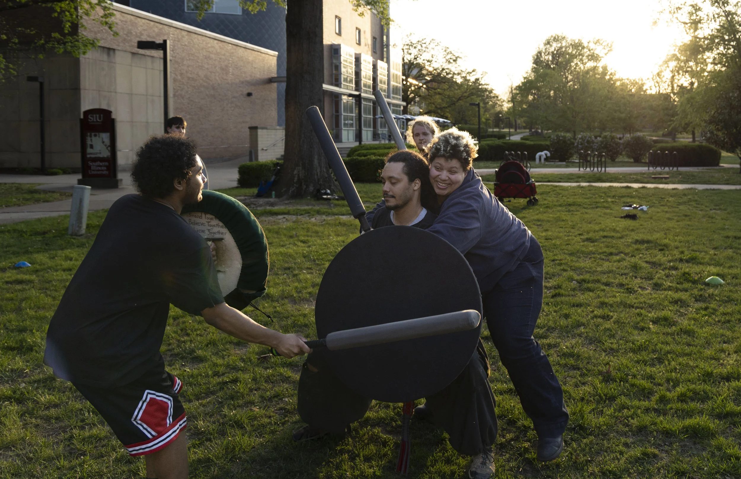 Jasmine Fleming (Skia) holds David LaBoube (Fumbles) so that Isaac Ramirez (Omen) can attack and eliminate him from the round at practice April 14, 2026 in front of Morris Library in Carbondale, Illinois. 