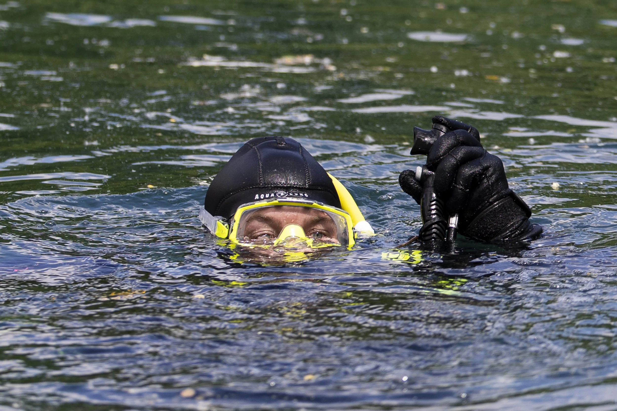 Diver Andrew Lucca lifts his buoyancy control device above the water to let out air and descend into the water April 25, 2026 at Mermet Springs in Belknap, Illinois.